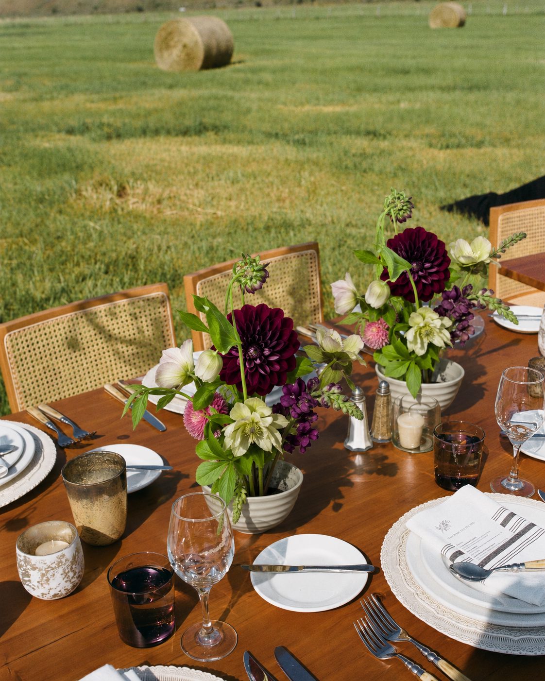 Sucker Floral Studio — burgundy dahlia centerpieces on an outdoor farm table
